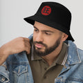 Black bucket hat with Madness Kanji 狂 (Kyō) embroidered artwork, left-front view