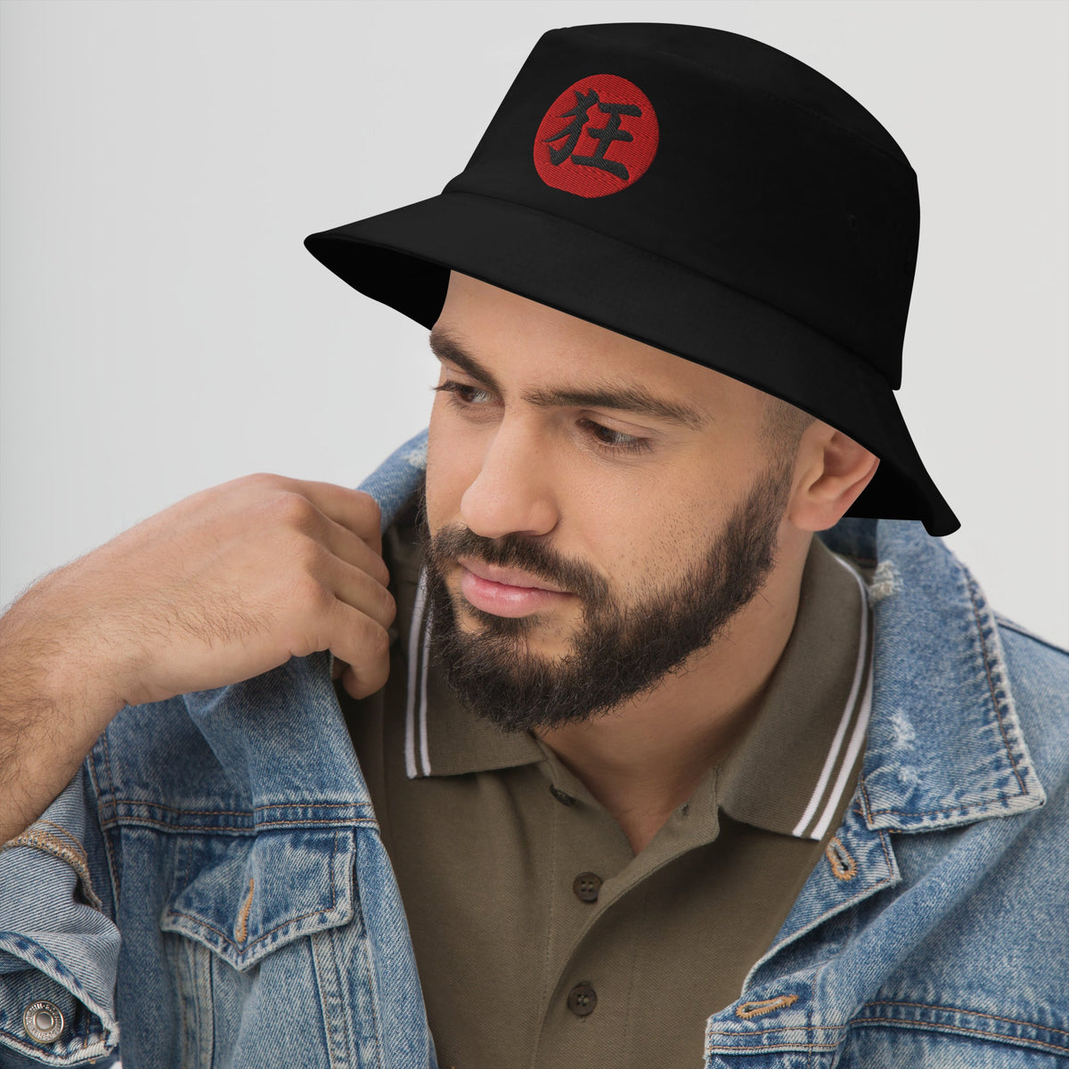 Black bucket hat with Madness Kanji 狂 (Kyō) embroidered artwork, left-front view