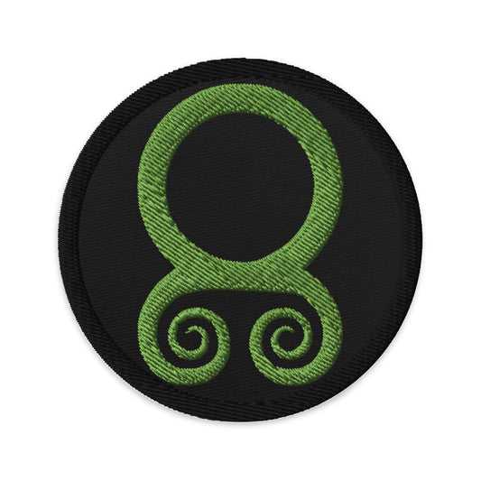 Circular embroidered patch featuring Troll Cross, front view