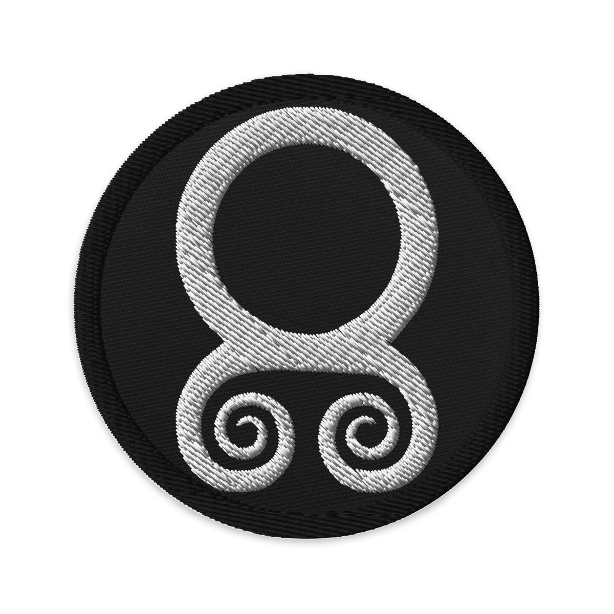 Circular embroidered patch featuring White Troll Cross, front view