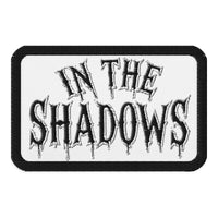 Rectangle embroidered patch featuring In The Shadows Iron On, front view