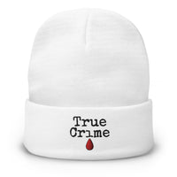 White cuffed beanie with True Crime Blood Drop embroidered artwork, front view