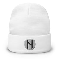 White cuffed beanie with Hagalaz Rune embroidered artwork, front view