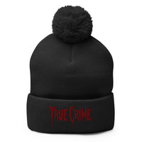 Black pom-pom beanie with Blood Drip True Crime embroidered artwork, front view
