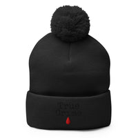 Black pom-pom beanie with True Crime Blood Drop embroidered artwork, front view