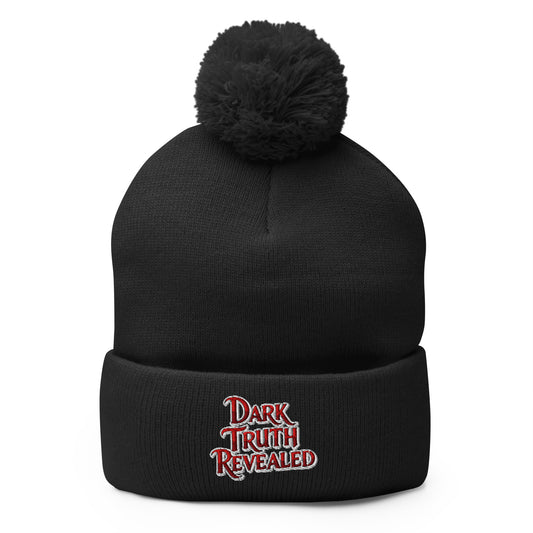 Black pom-pom beanie with Dark Truth Revealed embroidered artwork, front view