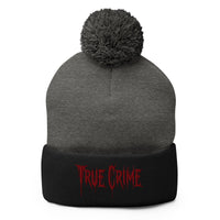 Black pom-pom beanie with Blood Drip True Crime embroidered artwork, front view