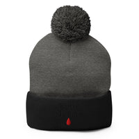 Black pom-pom beanie with True Crime Blood Drop embroidered artwork, front view