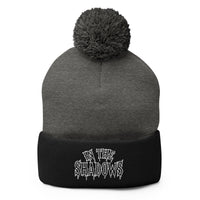 Black pom-pom beanie with In The Shadows embroidered artwork, front view