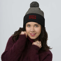 Black pom-pom beanie with Drawn to Darkness embroidered artwork, front view