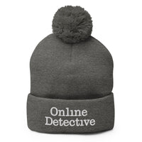 Gray pom-pom beanie with Online Detective embroidered artwork, front view