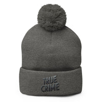 Gray pom-pom beanie with Detective Style True Crime embroidered artwork, front view
