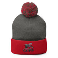 Red pom-pom beanie with Detective Style True Crime embroidered artwork, front view