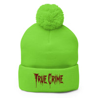 Green pom-pom beanie with Blood Drip True Crime embroidered artwork, front view