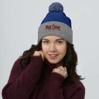 Gray pom-pom beanie with Blood Drip True Crime embroidered artwork, front view