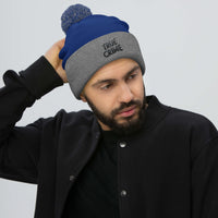 Gray pom-pom beanie with Detective Style True Crime embroidered artwork, front view