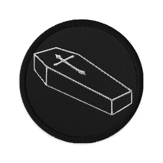 Circular embroidered patch featuring Toe Pincher Coffin with Cross, front view