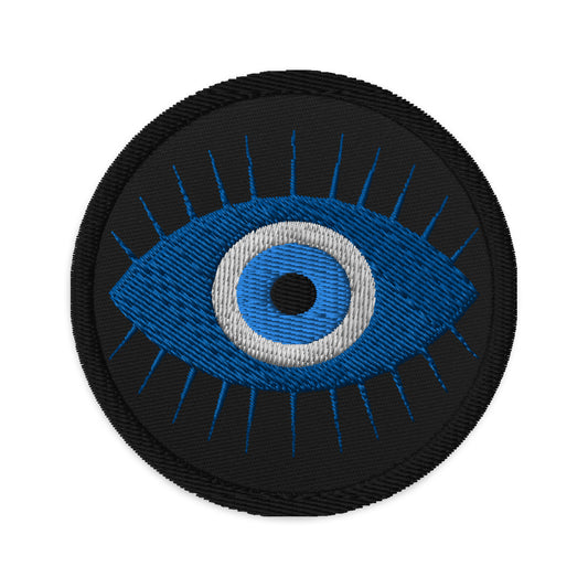 Circular embroidered patch featuring The Curse of the Evil Eye, front view