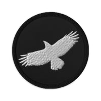 Circular embroidered patch featuring Flying Raven Black Bird, front view