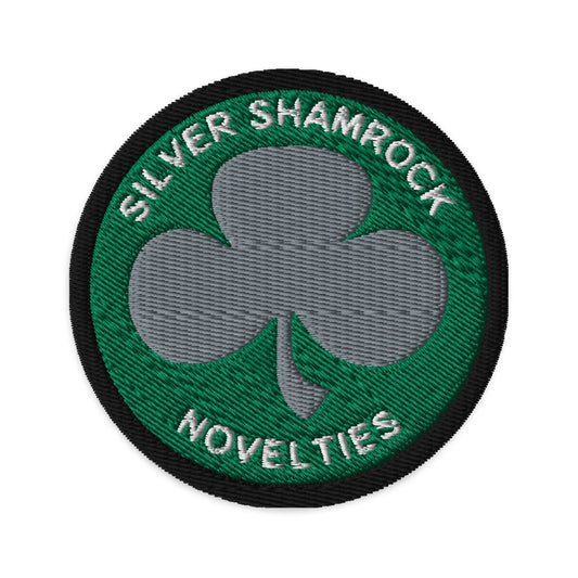 Circular embroidered patch featuring Silver Shamrock Novelties, front view