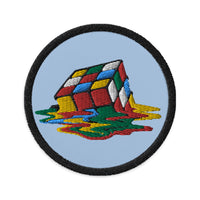 Circular embroidered patch featuring Melting Speed Cube Gaming Puzzle Box, front view