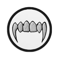 Circular embroidered patch featuring Vampire Fangs, front view